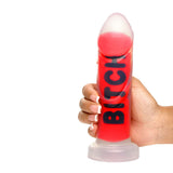 Hand holding the Master Series BITCH Silicone Dildo, featuring vibrant red color and bold lettering.