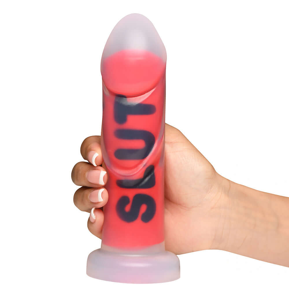 Hand holding the Master Series SLUT Silicone Dildo, showcasing its impressive design and body-safe silicone material.