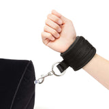 Lux Fetish Inflatable Position Wedge with Detachable Cuffs showing hand with cuff attached to wedge.