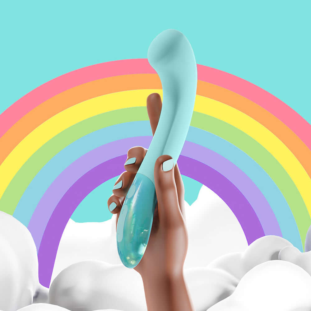 Biird Gii Glow Massager Mint held against a colorful rainbow backdrop, showcasing its sleek design.