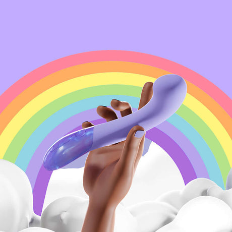 A hand holding the Biird Gii Glow Massager Lilac against a colorful rainbow background.