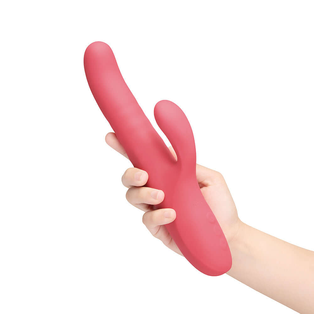 Hand holding the Le Wand Thrust Rabbit Vibrator, showcasing its sleek design and dual stimulation features.