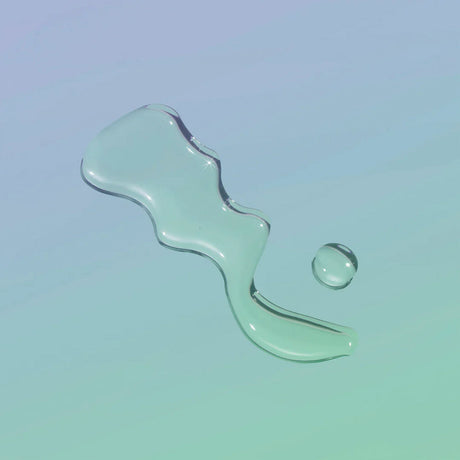 Playground Free Love Water-Based Personal Lubricant 3.7 Oz, clear lubricant droplet on light background.