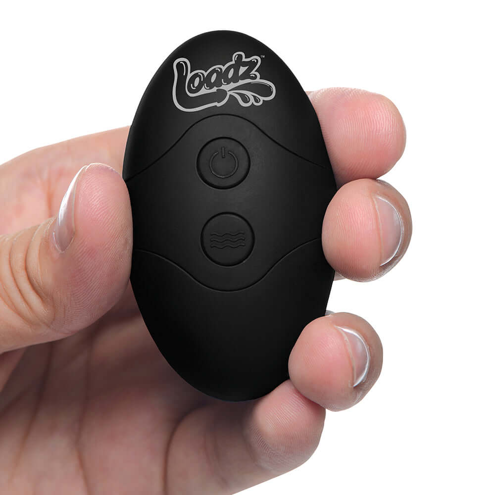 Loadz 8.5 inch Vibrating Squirting Dildo Dark remote control held in hand.