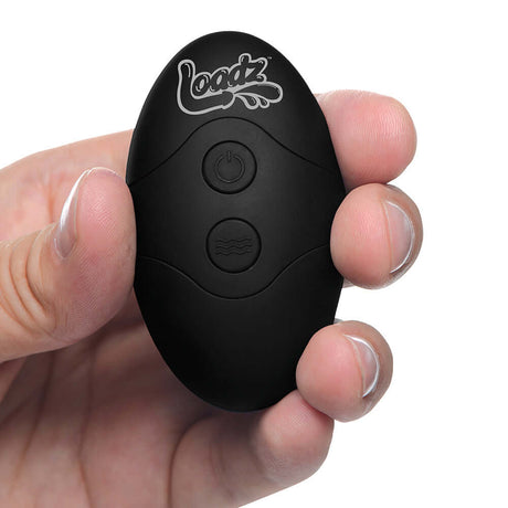 Loadz 8.5 inch Vibrating Squirting Dildo Dark remote control held in hand.