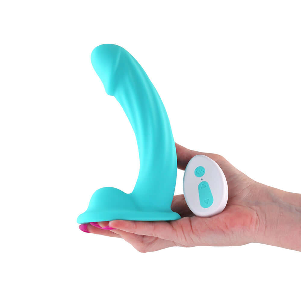 Colours Curve Vibrating 6 inch Dildo Teal with remote control in a hand on a white background.