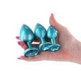 Rear Assets Trainer Metal Plug Kit Iridescent Teal displayed in hand, showcasing three chrome-plated plugs in iridescent teal.