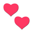 Glow-in-the-Dark Neon Pink Heart Pasties Nipple Covers in heart shapes, perfect for raves and parties.