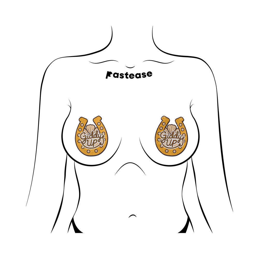 Pastease Giddy Up Sparkling Horseshoe Golden Nipple Covers shown on a model's chest, featuring gold glitter and rope-style lettering.