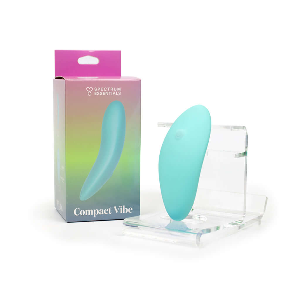 Spectrum Essentials Compact External Vibrator Blue next to its packaging on a display stand.