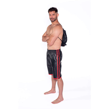 Man wearing black shorts with red stripes and a backpack, posing confidently against a white background.