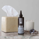 JO Stroker Lubricant 8 Oz bottle on a table with tissue and a candle, ideal for personal use.