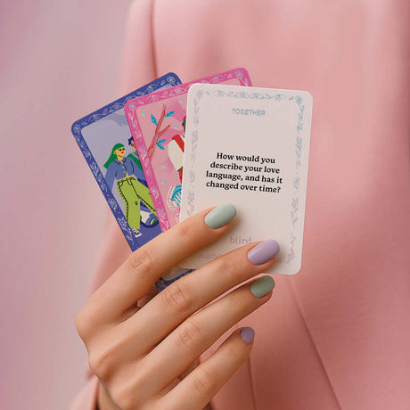 Hand holding Biird x Jouissance Club Together Couples Card Game conversation cards, exploring love languages.