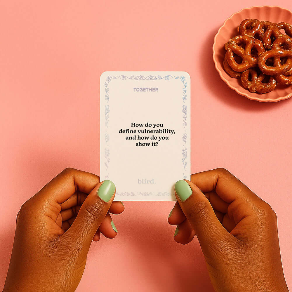 Person holding a card from Biird x Jouissance Club Together Couples Card Game with a question about vulnerability.