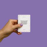Person holding a card from the Biird x Jouissance Club Together Couples Card Game on a lavender background.