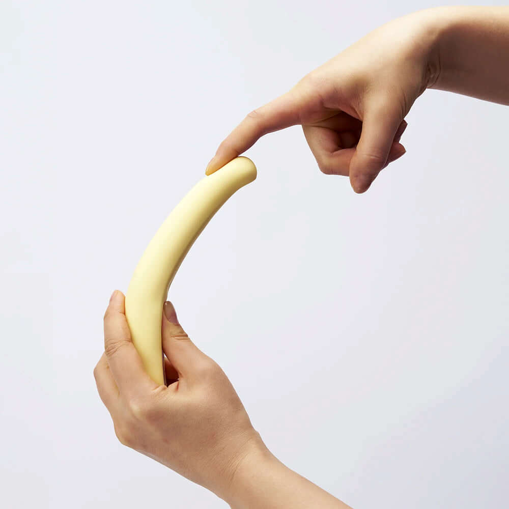 Hand holding the iroha tsuki MIKAZUKI Massager, showcasing its curved design and flexible structure.