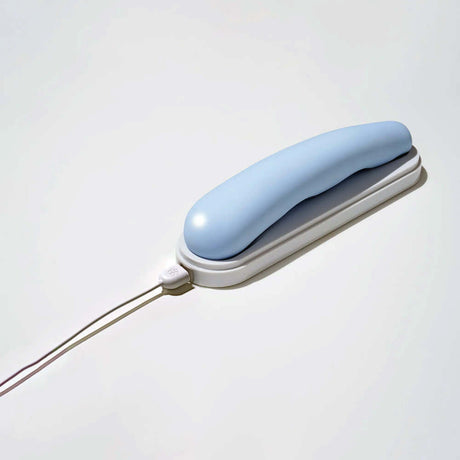 iroha tsuki MINAMO Massager in soft blue color with charging cable on a white background.