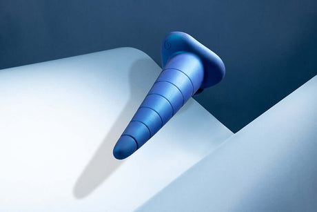 b-Vibe Anal Stretcher Training Cone on a sleek surface, highlighting its cone shape and textured design.