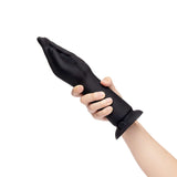Hand holding the b-Vibe Vibrating Silicone Fisting Dildo, showcasing its unique design and soft silicone material.