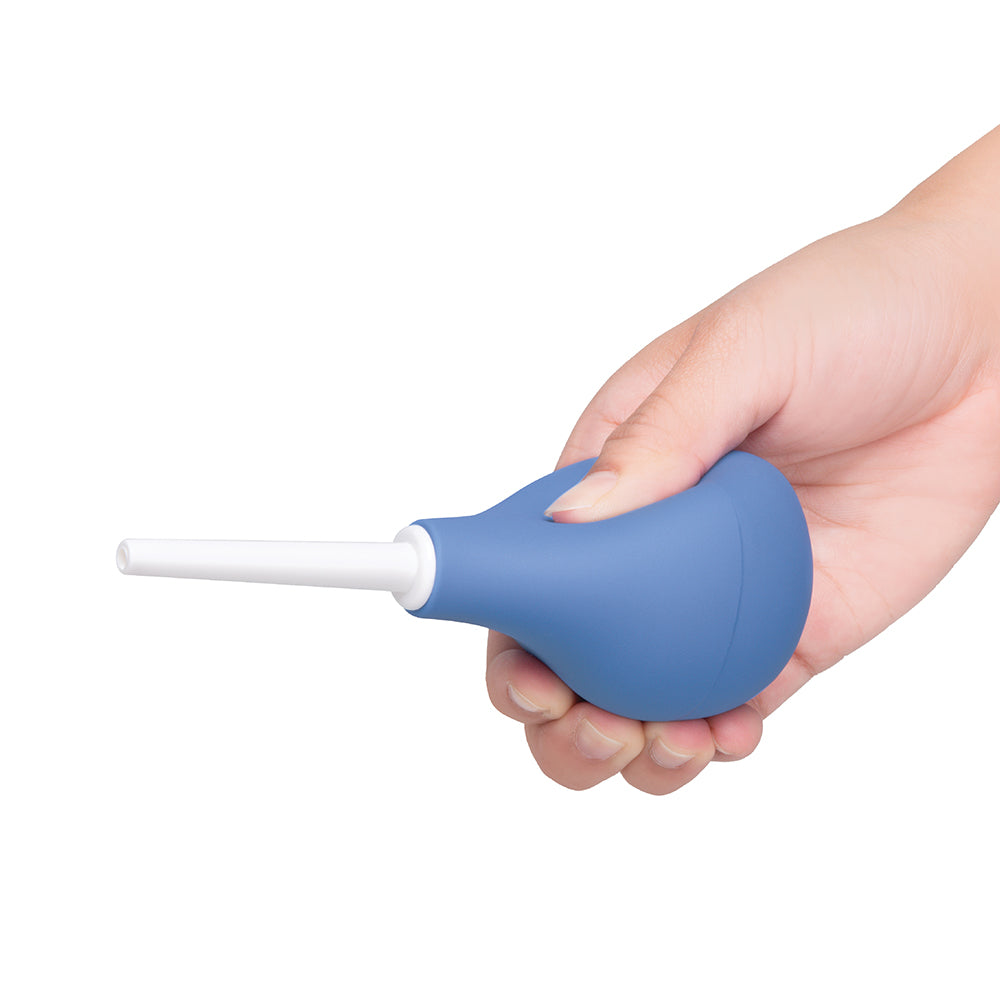 b-Vibe Compact Enema Douche Blue held in a hand, showcasing its ergonomic design and travel-friendly features.