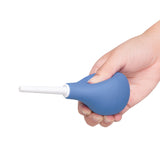 b-Vibe Compact Enema Douche Blue held in a hand, showcasing its ergonomic design and travel-friendly features.