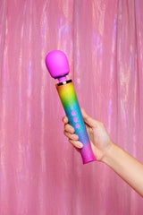 Le Wand Petite All That Glimmers Ombre held against a pink backdrop, showcasing its vibrant rainbow ombre design.