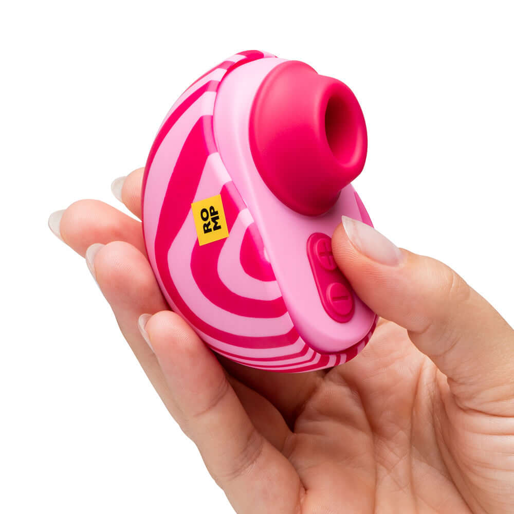 ROMP Spin Travel Rechargeable Clitoral Stimulator in hand, showcasing its vibrant design and controls.