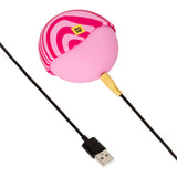 ROMP Spin Travel Rechargeable Clitoral Stimulator in pink with USB charging cable.