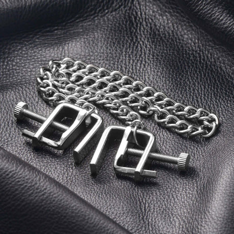 Master Series Pressure Vice Metal Nipple Clamps on a black leather background with a chain.
