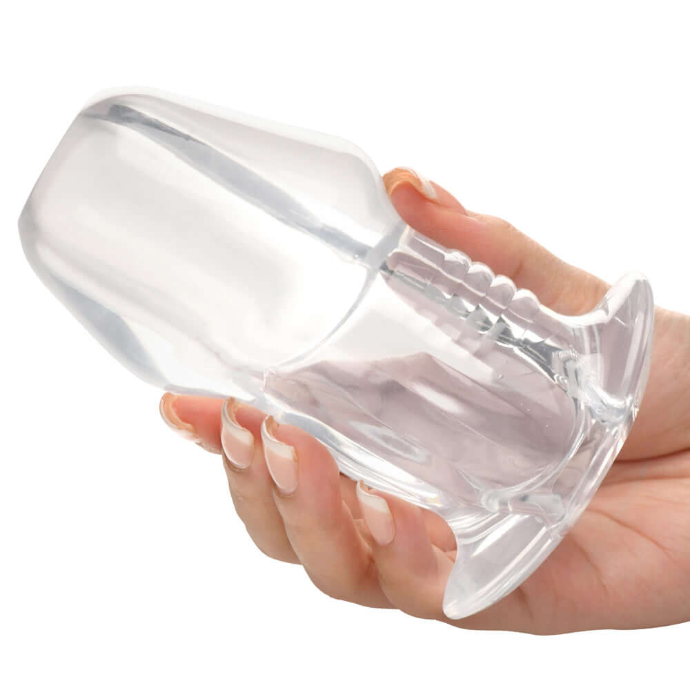 Person holding the Master Series Dicked Clear Hollow Anal Plug Large showcasing its transparent design.