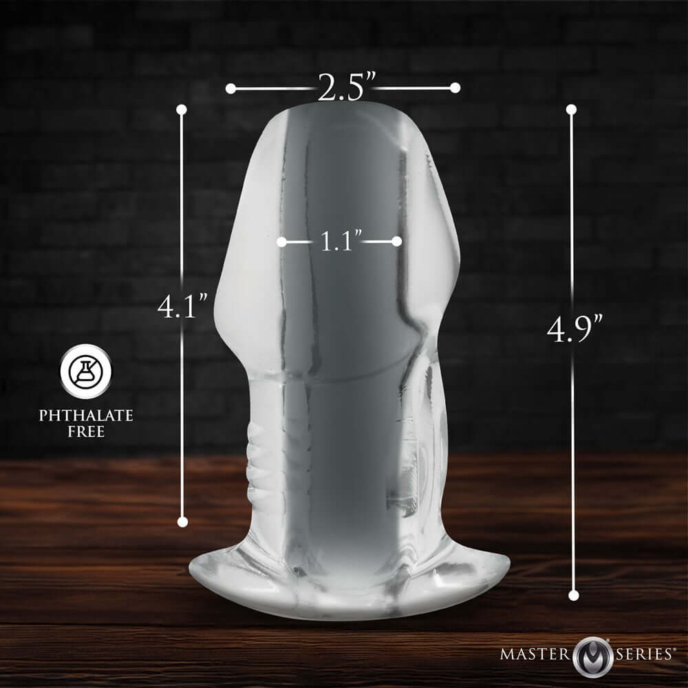Master Series Dicked Clear Hollow Anal Plug Large with dimensions marked on a wooden background