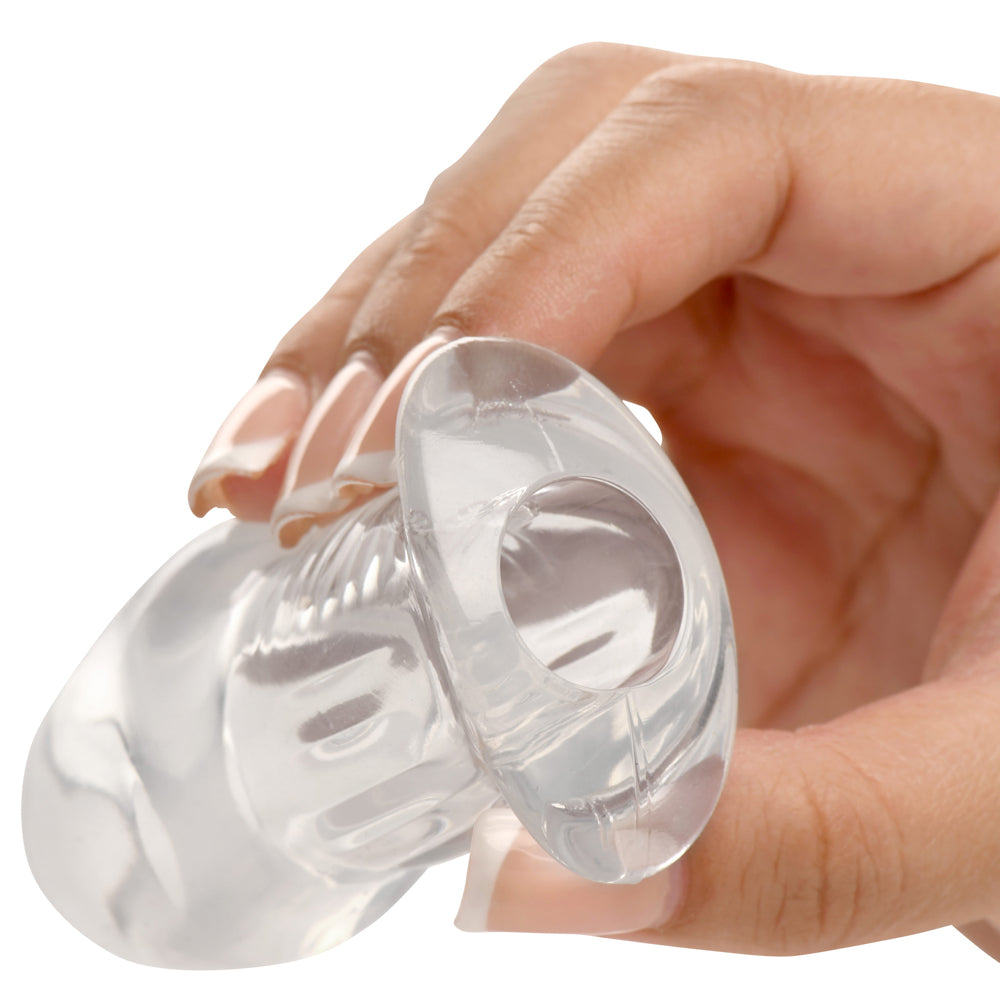 Hand holding the Master Series Dicked Clear Hollow Anal Plug Small showcasing its transparent design.