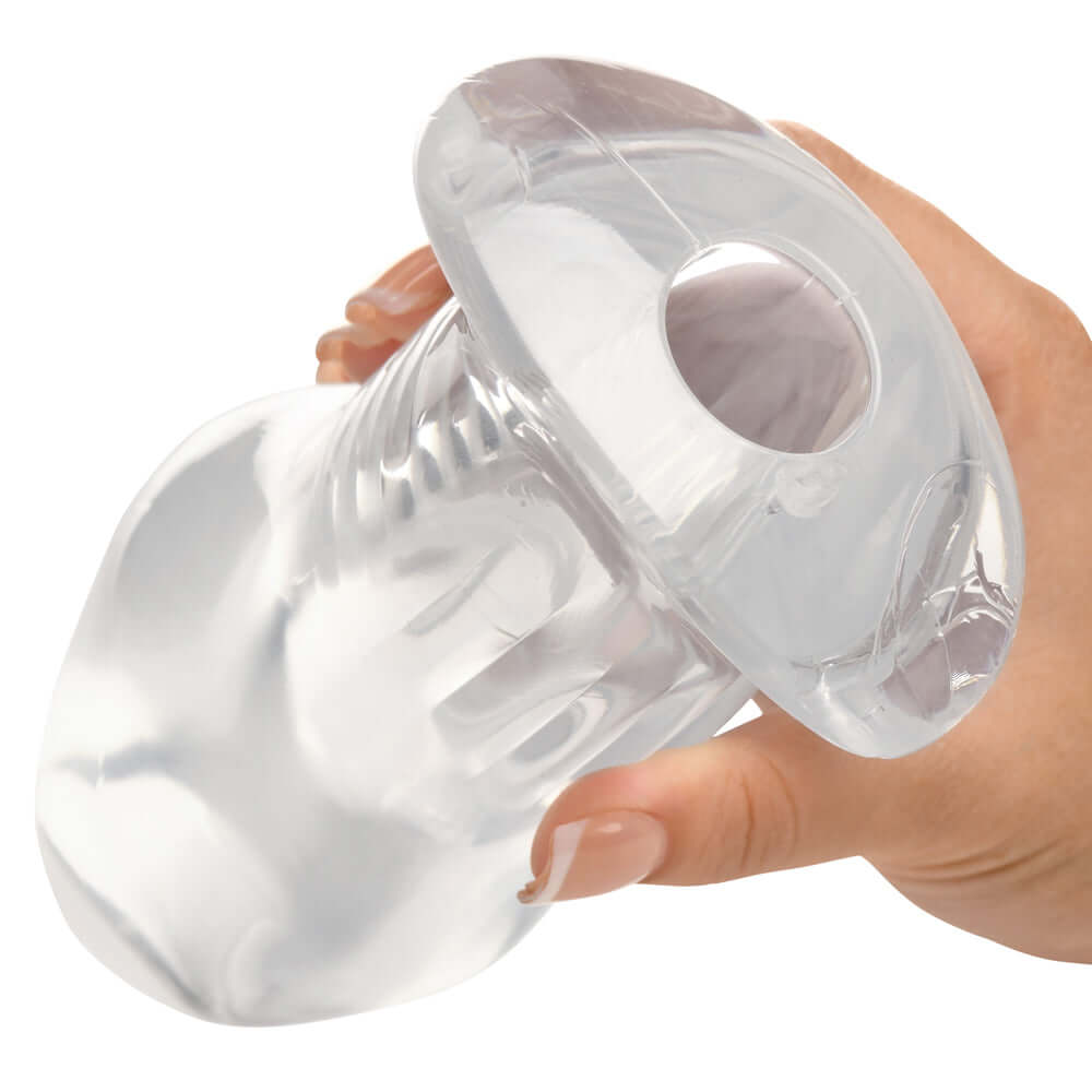 Master Series Dicked Clear Hollow Anal Plug XLarge held in hand, showcasing its transparent hollow design.