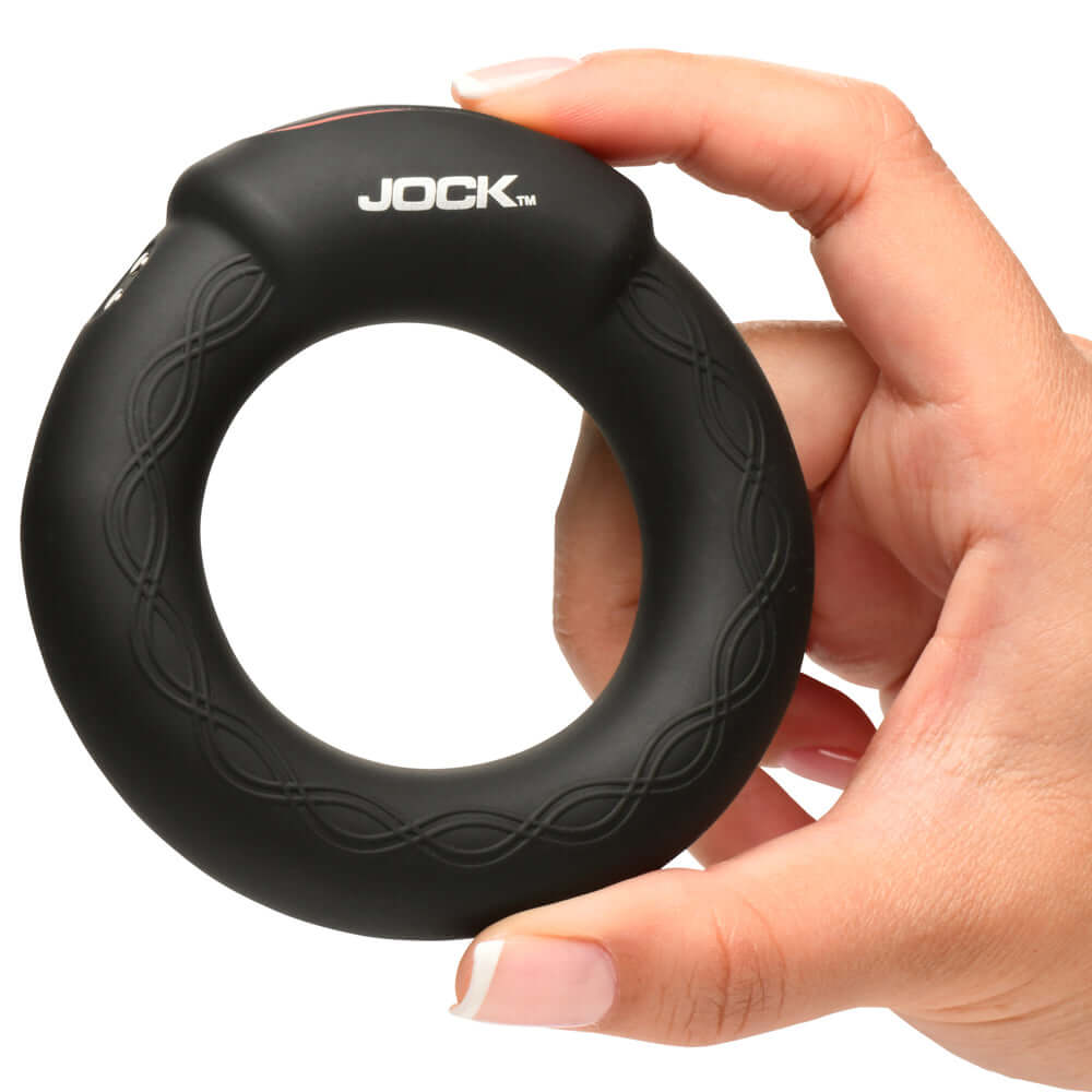 A hand holding the JOCK Rumbler 2 inch Vibrating & Warming C-Ring, showcasing its sleek silicone design.