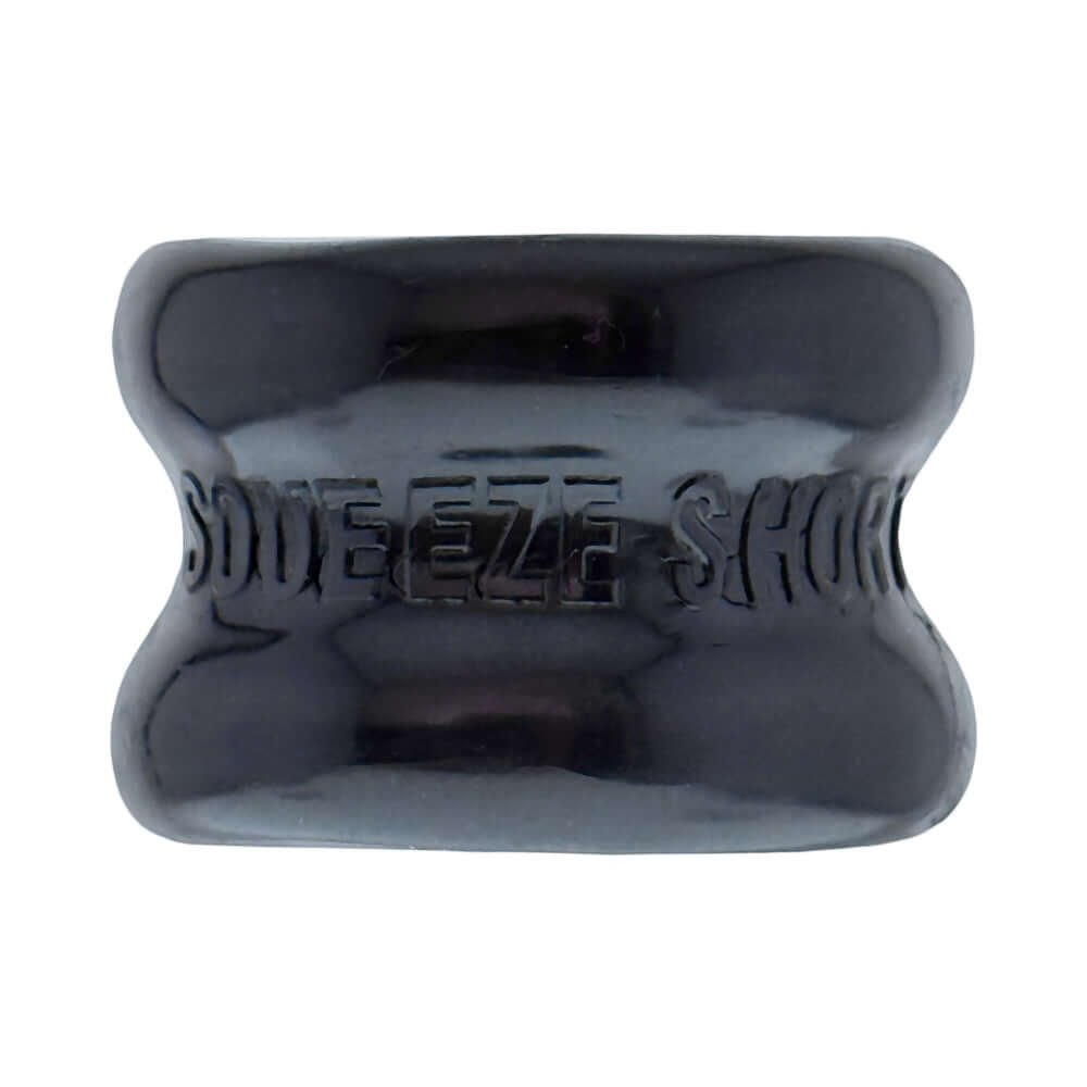 Oxballs Squeeze Short Ballstretcher Black shown from above, highlighting its compact design and hourglass shape.
