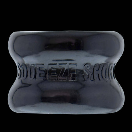 Oxballs Squeeze Short Ballstretcher Black, a compact hourglass-shaped ball stretcher for secure stretching.
