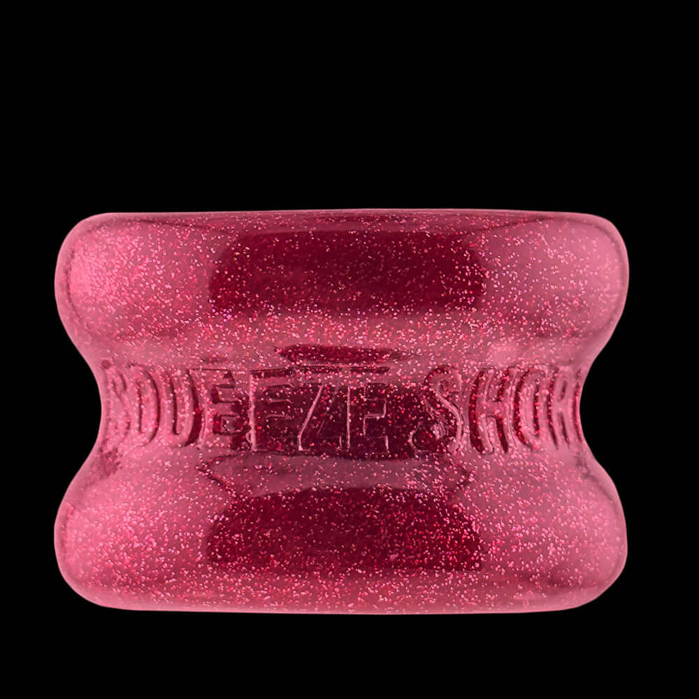 Oxballs Squeeze Short Ballstretcher Cherry Lips showing a shiny, glittery red design with an hourglass shape.
