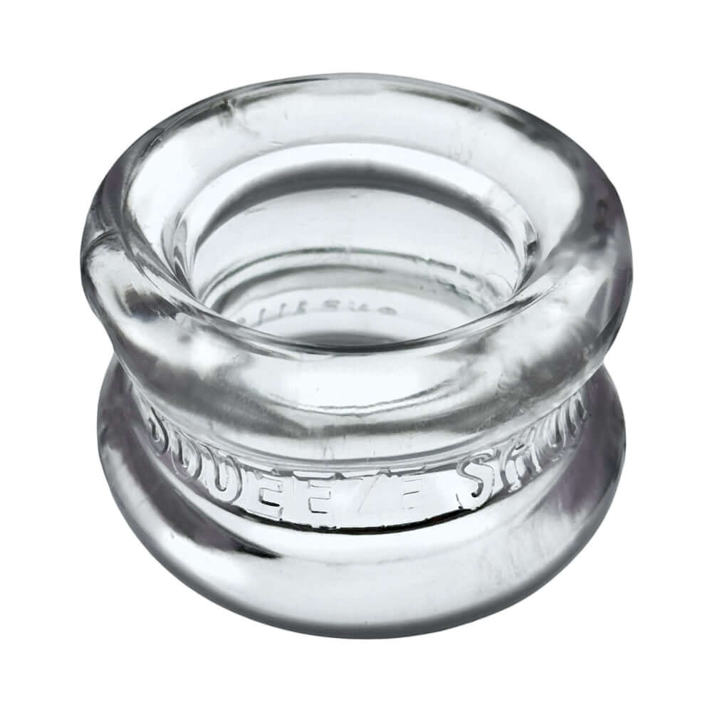 Oxballs Squeeze Short Ballstretcher Clear, a transparent, hourglass-shaped ball stretcher for comfortable use.