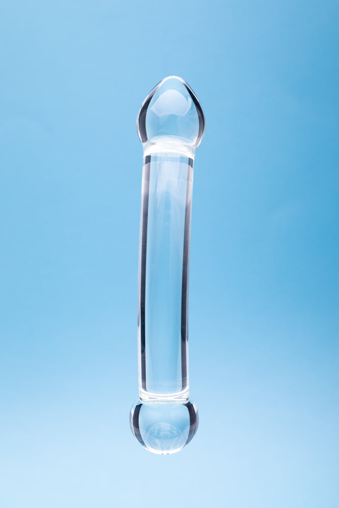 Clarity Celestial Purity Glass Dildo against a blue background, showcasing its elegant design and craftsmanship.