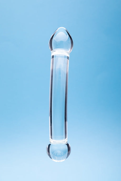 Clarity Celestial Purity Glass Dildo against a blue background, showcasing its elegant design and craftsmanship.