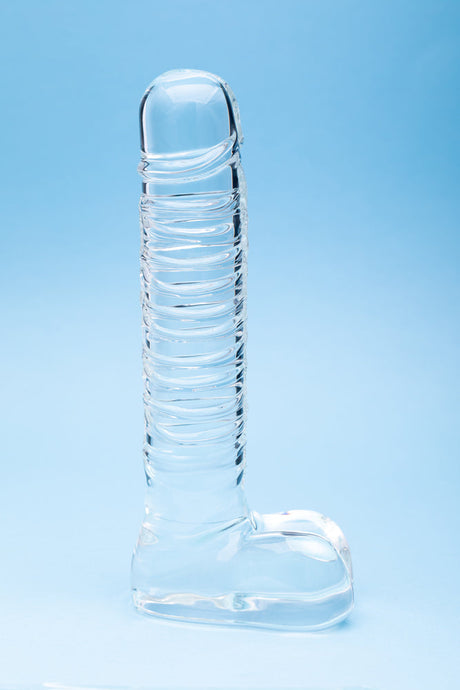 Clarity Seraphic Opus Glass Dildo on a blue background, showcasing its elegant design and handblown craftsmanship.