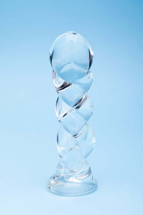 Clarity Seraphic Braid Glass Dildo on a blue background showcasing its unique spiral design.