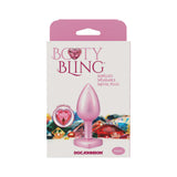 Booty Bling Heart Diamond Jeweled Metal Plug Pink Small in packaging with colorful background.