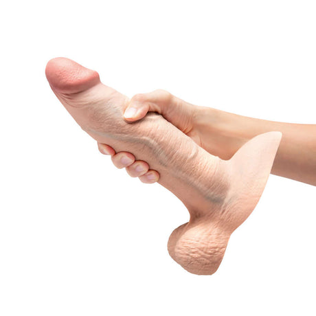 b-Vibe Slipskin Realistic Silicone Dildo 9 inch Girthy Cream held in hand to show lifelike design and texture.