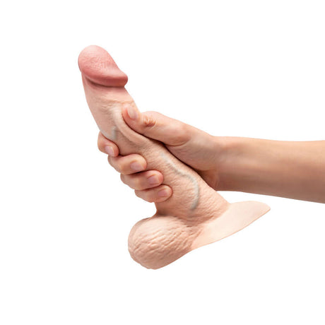 b-Vibe Slipskin Realistic Silicone Dildo 8 inch Curved Cream held in hand to showcase realistic design and texture.