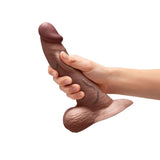 b-Vibe Slipskin Realistic Silicone Dildo 8 inch Curved Brown held in hand, showcasing its lifelike design and curvature.