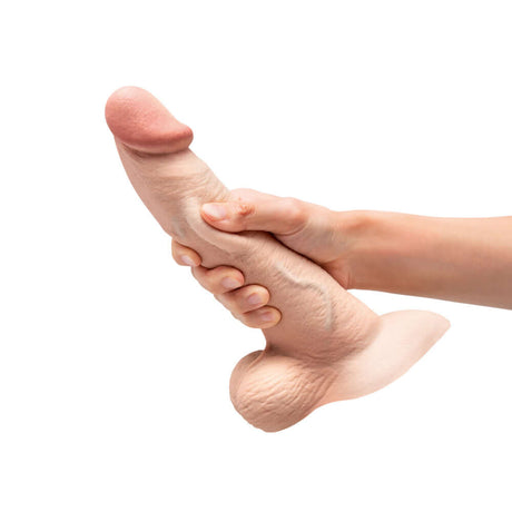 b-Vibe Slipskin Realistic Silicone Dildo 9 inch Curved Cream held in a hand for demonstration.