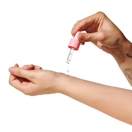 Applying Eye of Love Pheromone Perfume Oil 0.67 Oz Dropper Sunny Daze on wrist with dropper.