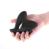 Renegade Rain Prostate Massager with Remote Control Black held in a hand, showcasing its sleek silicone design.