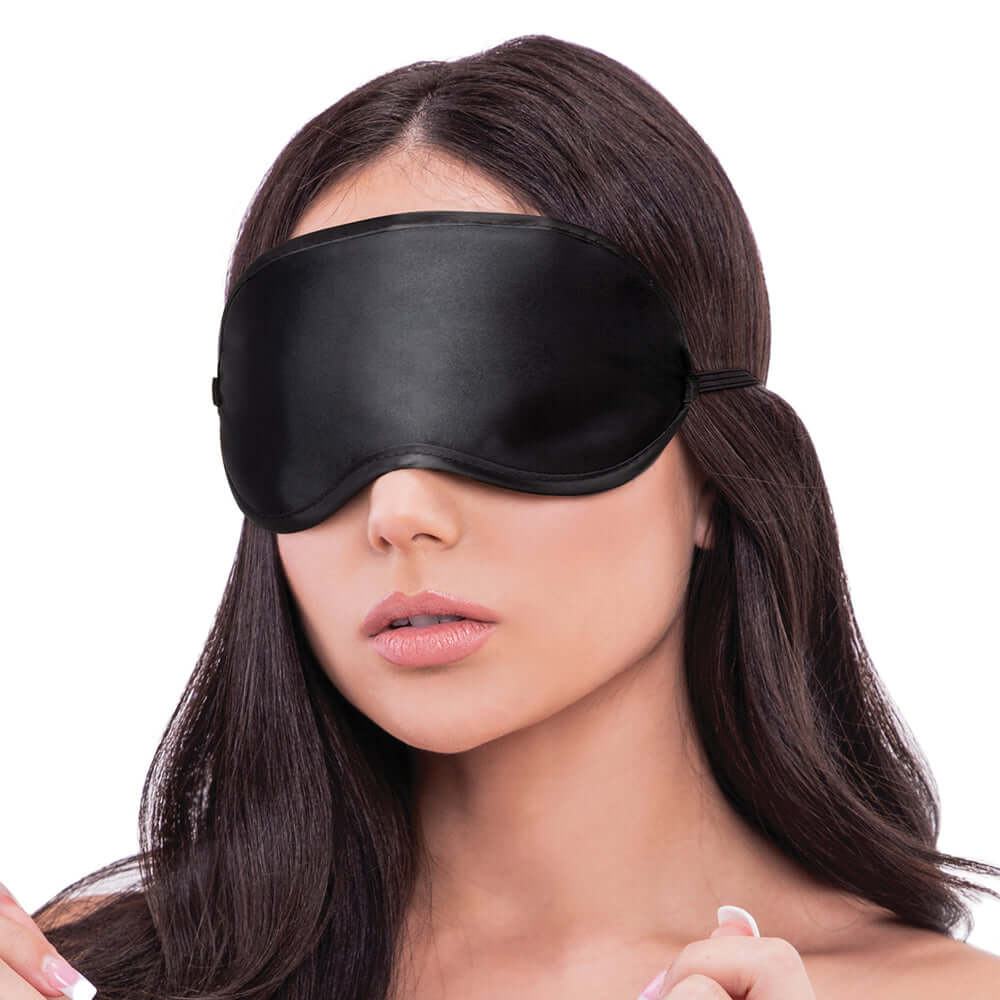 Woman wearing a black Lux Fetish blindfold with a smooth finish, highlighting intimacy and sensory play.